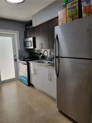 a kitchen with stainless steel appliances a refrigerator sink and stove