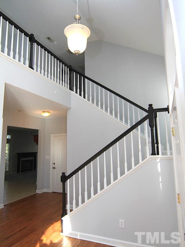 9021 Breeland Way Raleigh, NC 27613 - Photo 2 of 20 a view of staircase with wooden floor and a chandelier