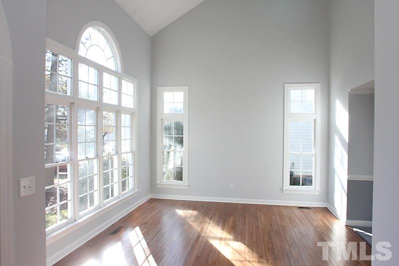 9021 Breeland Way Raleigh, NC 27613 - Photo 4 of 20 a view of an empty room with wooden floor and a window