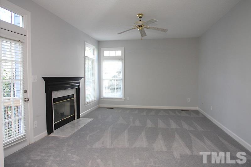 9021 Breeland Way Raleigh, NC 27613 - Photo 10 of 20 an empty room with windows and fireplace