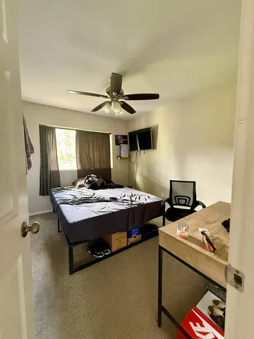 a bed room with a bed and a ceiling fan