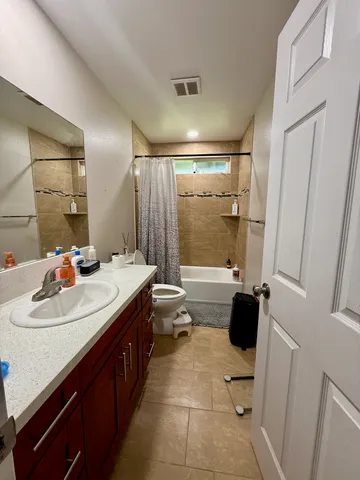 a bathroom with a sink a toilet a mirror and shower
