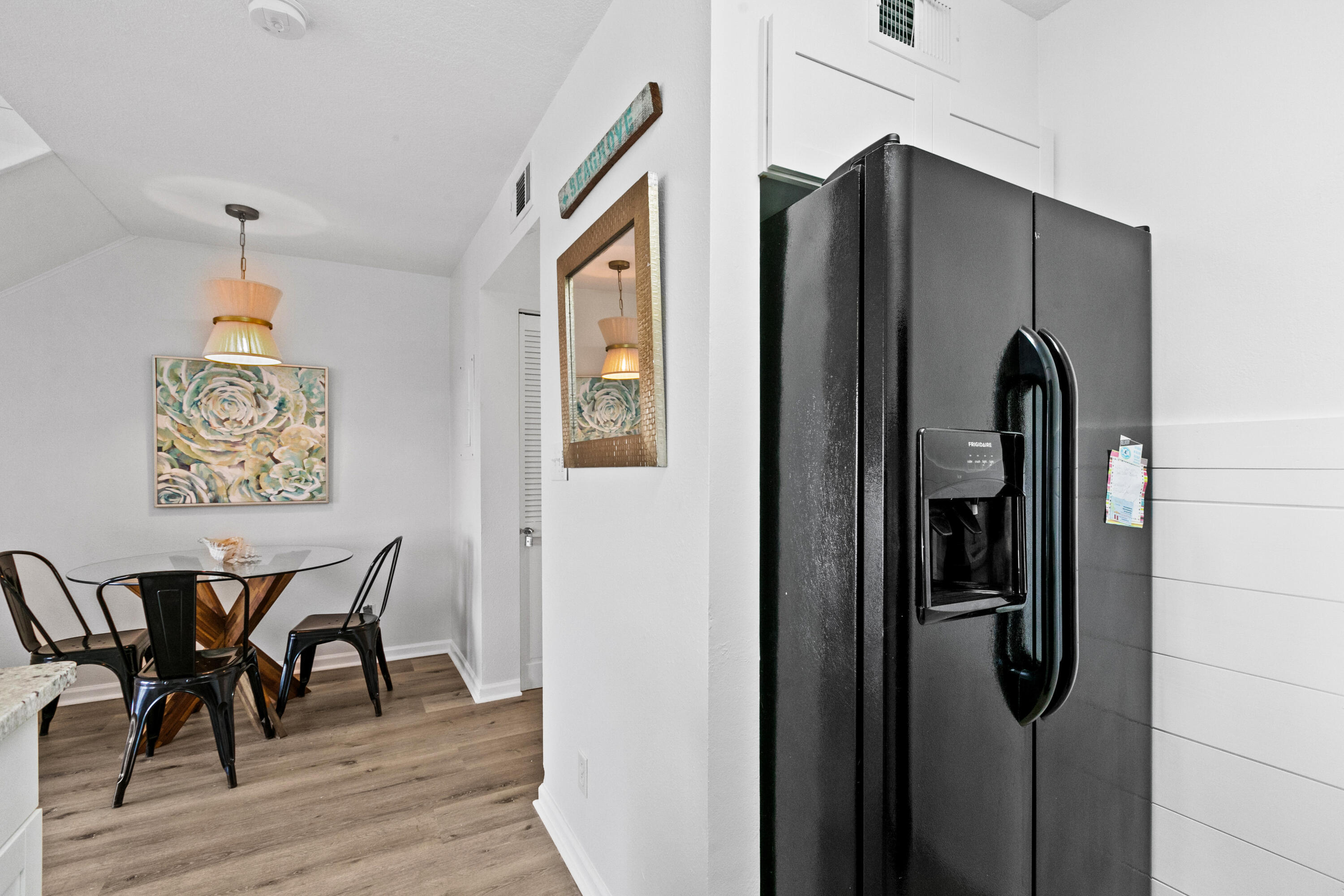145 Beachfront Trail, Unit 302A Santa Rosa Beach, FL 32459 - Photo 6 of 21 a view of a refrigerator and dining area with wooden floor