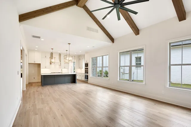 a view of a kitchen with wooden floor and stainless steel appliances