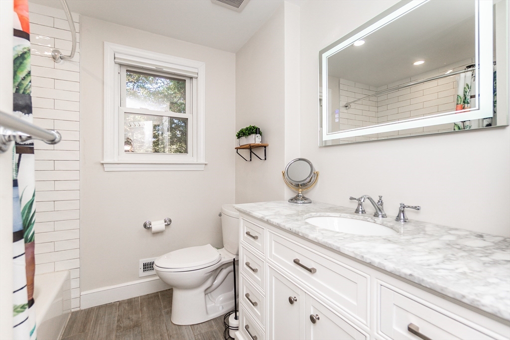 8 Sawyer Avenue Canton, MA 02021 - Photo 7 of 13 a bathroom with a granite countertop toilet a sink and a mirror