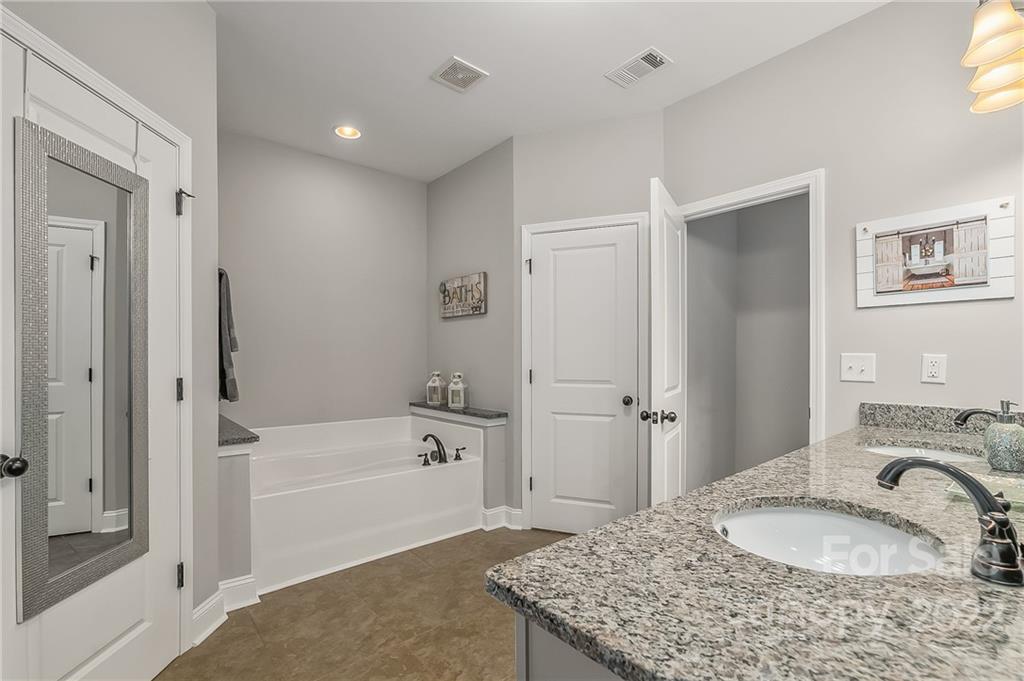624 Spur Alley, Unit 19 Rutherfordton, NC 28139 - Photo 21 of 41 a bathroom with a granite countertop sink a bathtub and shower