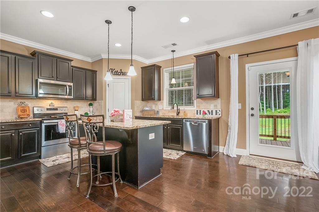 624 Spur Alley, Unit 19 Rutherfordton, NC 28139 - Photo 6 of 41 a kitchen with kitchen island granite countertop a stove a sink a oven a dining table and chairs