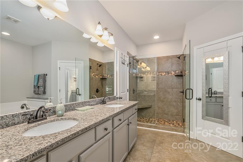 624 Spur Alley, Unit 19 Rutherfordton, NC 28139 - Photo 9 of 41 a bathroom with a granite countertop sink a mirror a shower and a bathtub