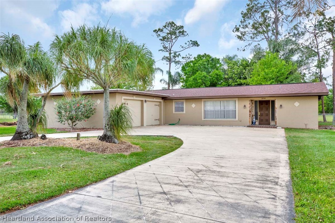 3232 Golfview Road Sebring, FL 33875 - Photo 1 of 36 a front view of a house with a yard and a garden