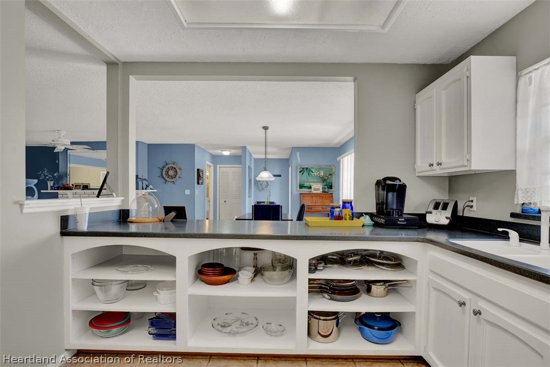 3232 Golfview Road Sebring, FL 33875 - Photo 12 of 36 a kitchen with a stove a microwave and cabinets