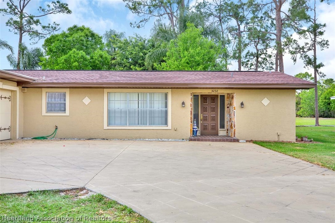 3232 Golfview Road Sebring, FL 33875 - Photo 33 of 36 a front view of a house with a garden and garage