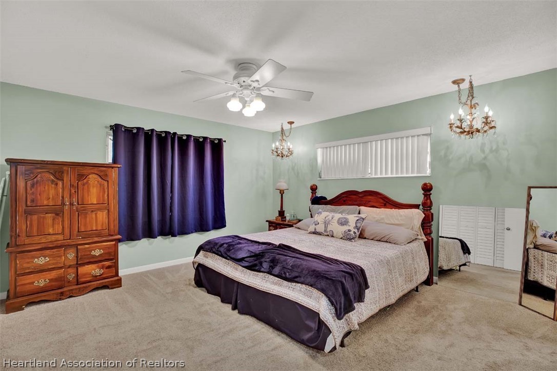 3232 Golfview Road Sebring, FL 33875 - Photo 7 of 36 a bedroom with a bed and a chandelier