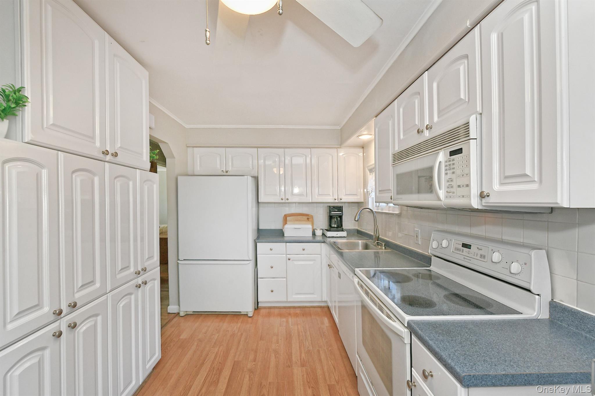 115 Old Farmingdale Road West Babylon, NY 11704 - Photo 12 of 30 a kitchen with a refrigerator sink and cabinets