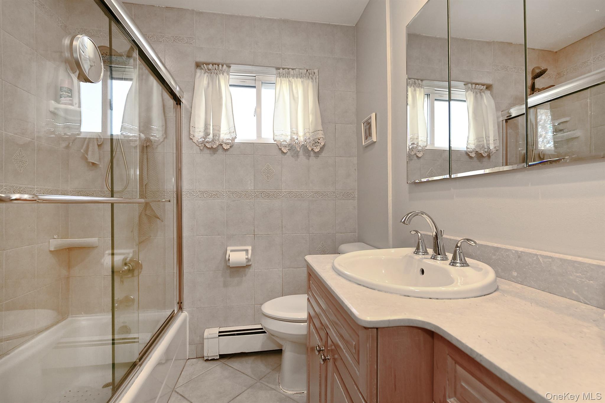 115 Old Farmingdale Road West Babylon, NY 11704 - Photo 19 of 30 a bathroom with a sink a toilet and shower