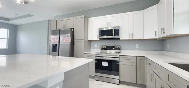 a kitchen with stainless steel appliances a stove microwave and refrigerator