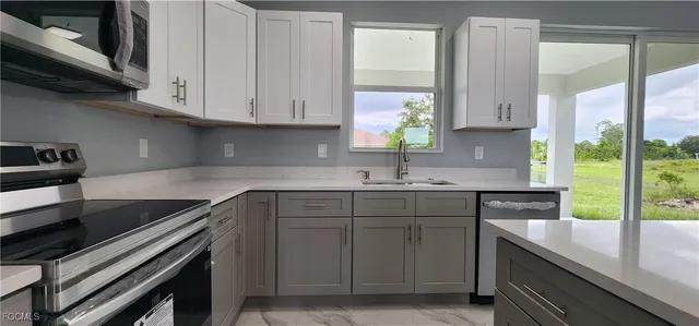 a kitchen with stainless steel appliances white cabinets and a sink