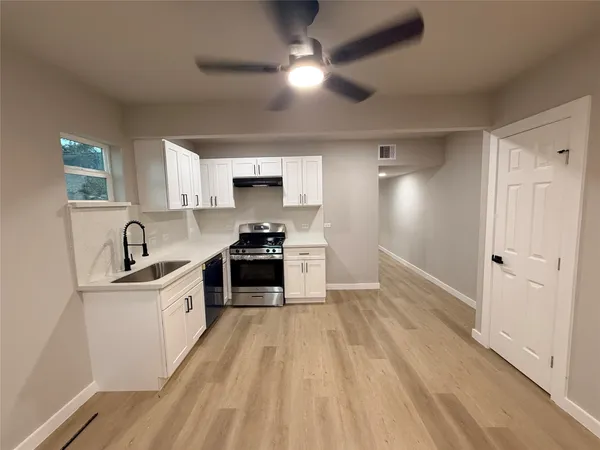 a kitchen with granite countertop a sink appliances cabinets and a counter top space