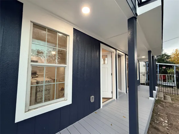 a view of a hallway with wooden floor and windows
