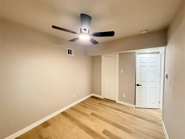 a view of empty room with wooden floor