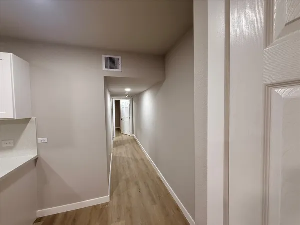 a view of a hallway with wooden floor
