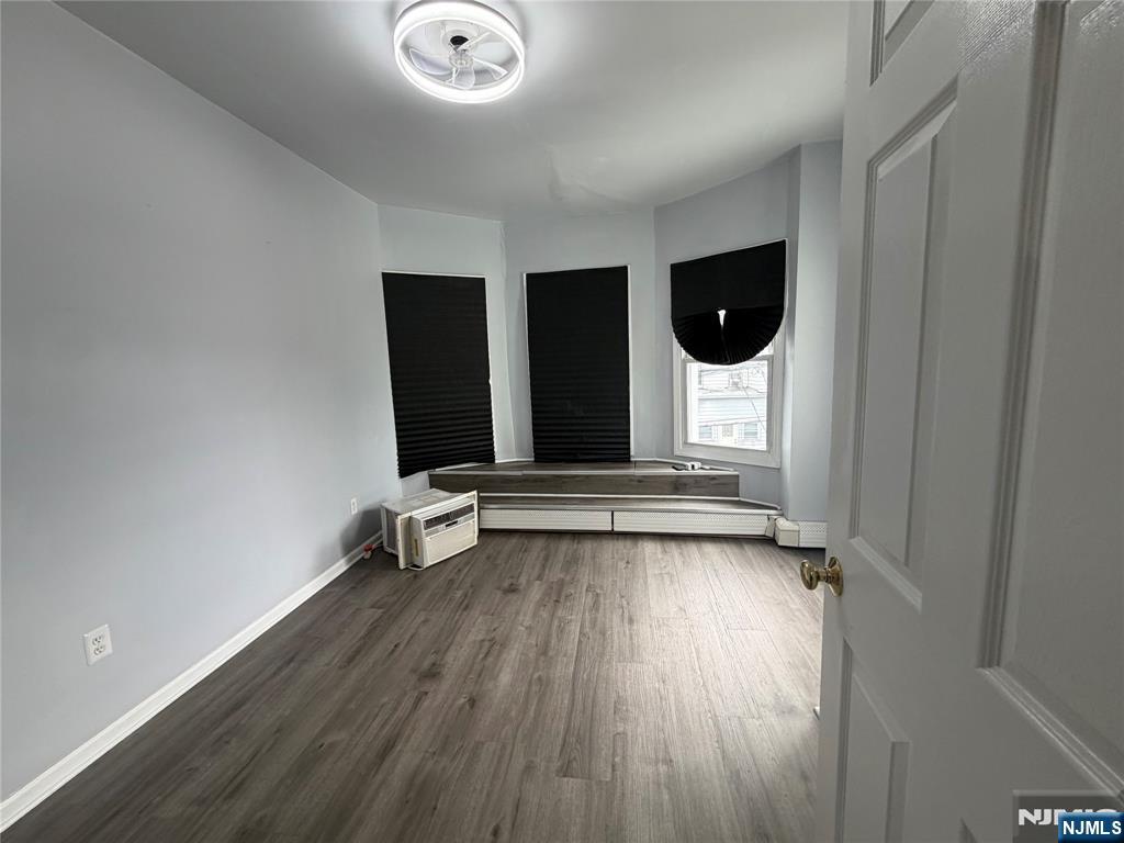 65 Grand Street Paterson, NJ 07501 - Photo 4 of 9 an empty room with wooden floor and windows