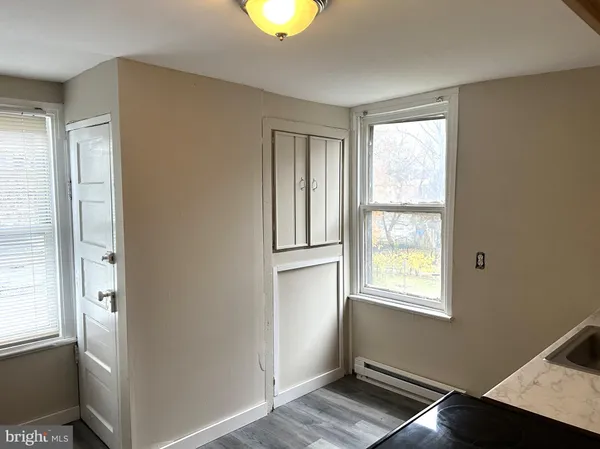 a view of an empty room with window and closet area