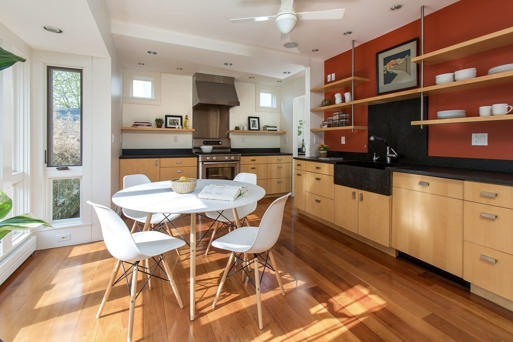 76 Prince Street Boston, MA 02130 - Photo 8 of 23 a dining area with stainless steel appliances granite countertop a stove a sink a dining table and chairs with wooden floor
