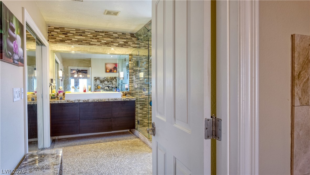 3704 North Campbell Road Las Vegas, NV 89129 - Photo 31 of 38 Luxurious vanity and shower area with contemporary finishes for a private retreat.