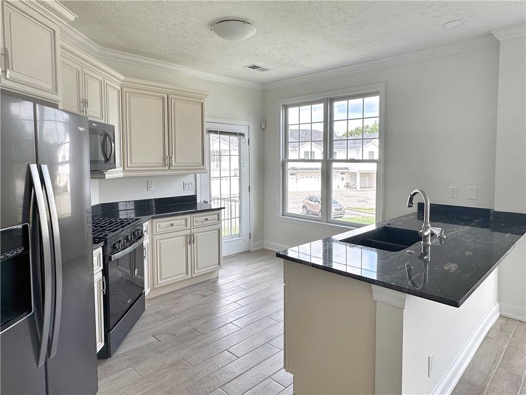 228 Adams Pointe Boulevard, Unit 7 Mars, PA 16046 - Photo 5 of 27 a kitchen with stainless steel appliances granite countertop a sink a stove and a refrigerator