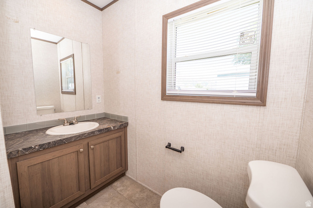 2491 Highway 89, Unit 403 Pleasant View, UT 84404 - Photo 22 of 32 Bathroom vanity with wood-finish cabinetry, a white basin, and a dark patterned countertop