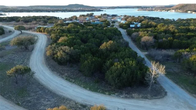 an aerial view of residential houses with outdoor space and trees