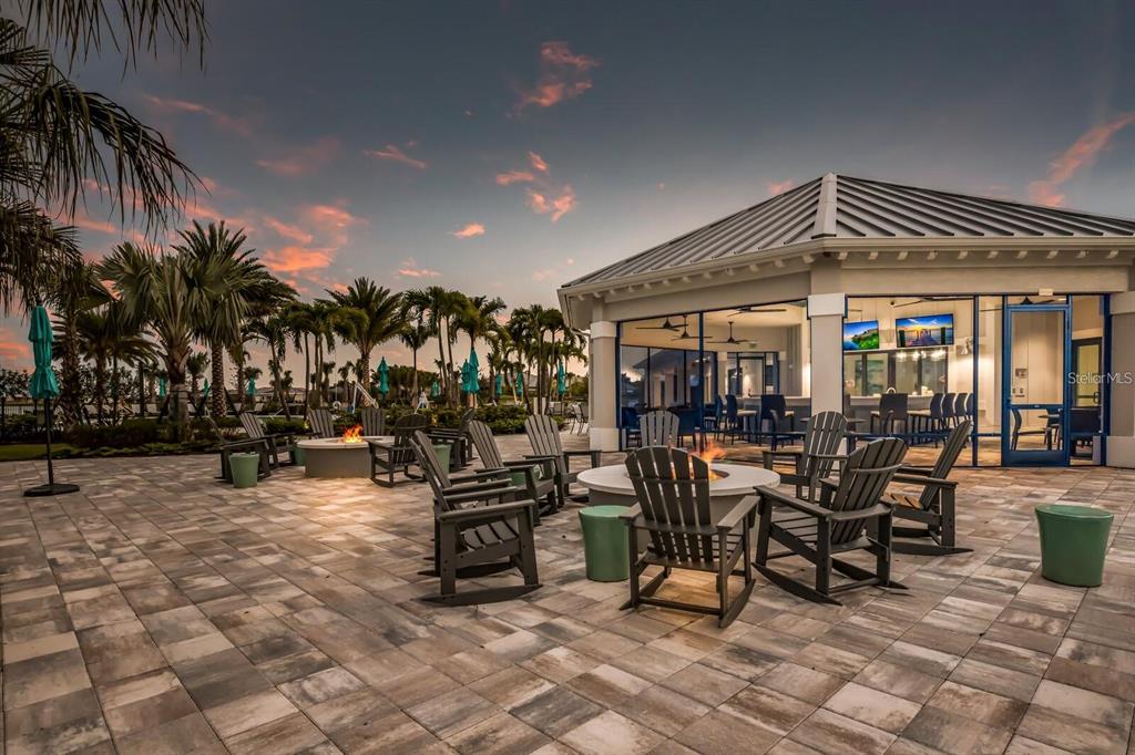 712 Sigsbee Loop Sarasota, FL 34240 - Photo 44 of 59 a view of a patio with dining table and chairs with plants and palm trees