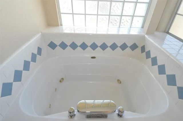 a bathroom with a tub a sink and mirror