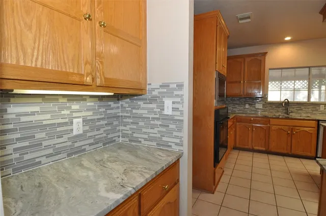 a kitchen with granite countertop a sink and a stove