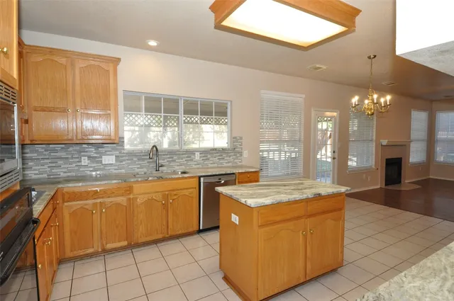 a kitchen with granite countertop a sink a counter top space and cabinets