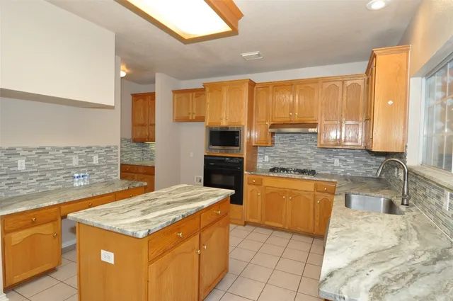 a kitchen with stainless steel appliances granite countertop wooden cabinets and a granite counter tops