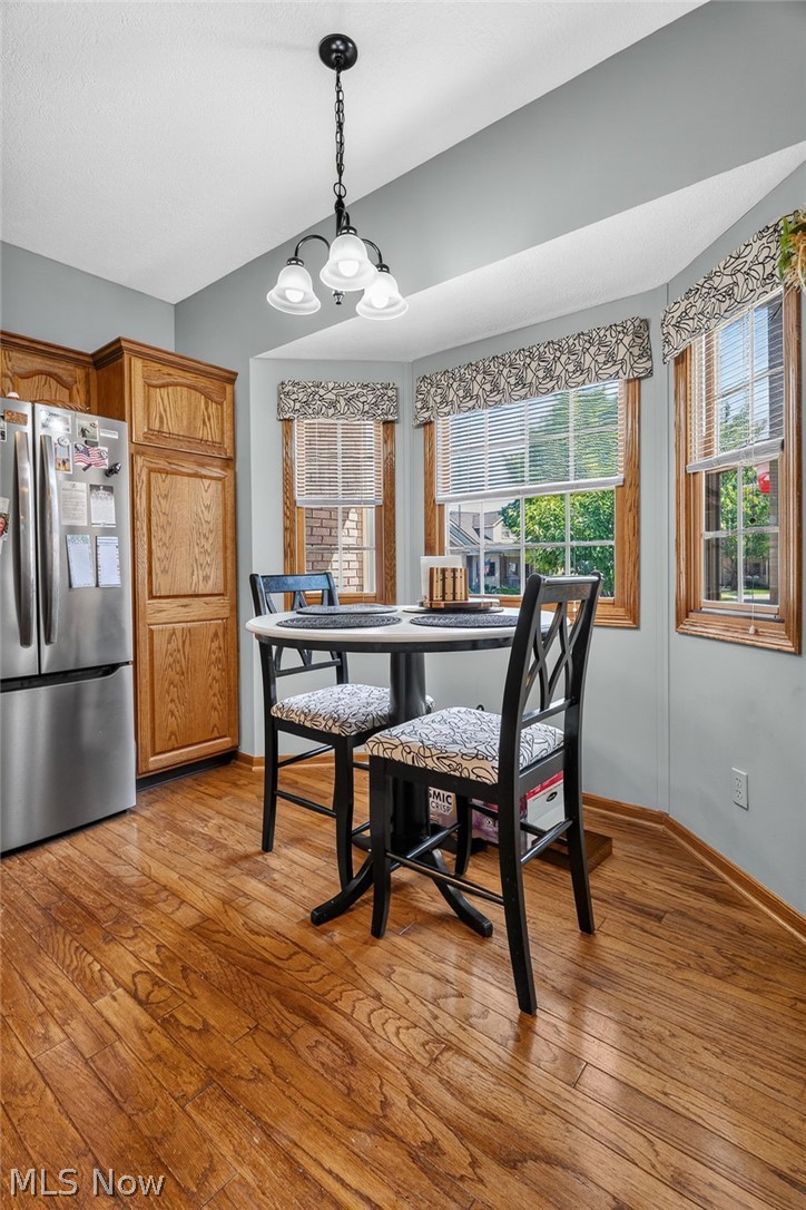 2601 Charing Cross Road Northwest Canton, OH 44708 - Photo 7 of 49 Hardwood-finish flooring, wood cabinetry, stainless steel refrigerator, bay window area, and a ceiling-mounted light fixture