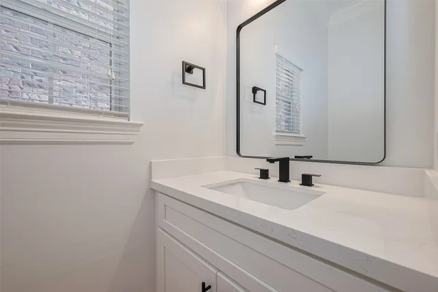 a bathroom with a sink vanity mirror and toilet