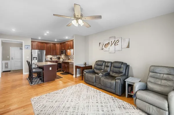 a living room with furniture kitchen view and a chandelier