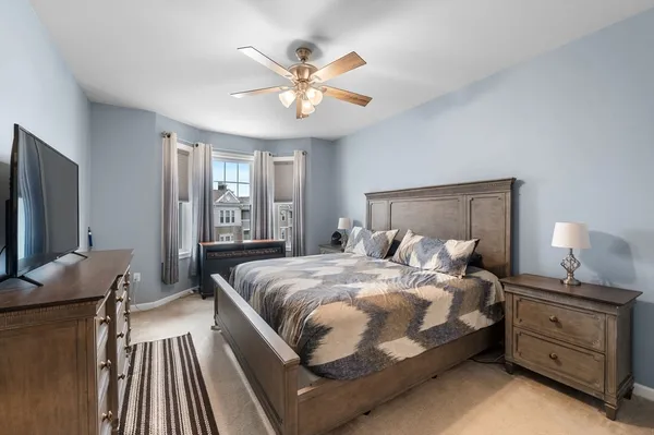 a bedroom with a bed and a flat tv screen on dresser