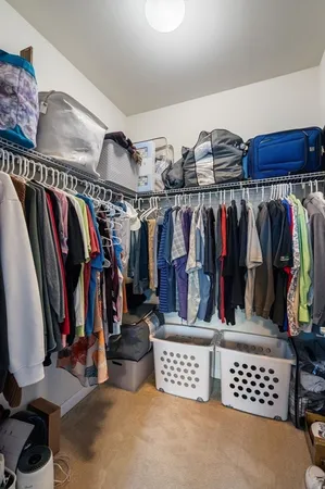 a view of walk in closet with clothes