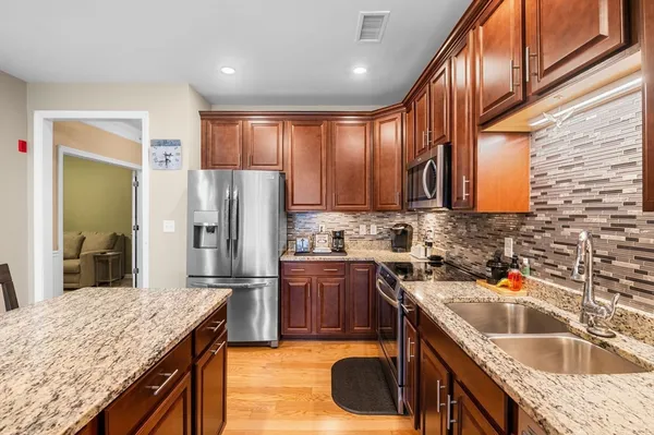 a kitchen with stainless steel appliances granite countertop a sink a stove and a refrigerator