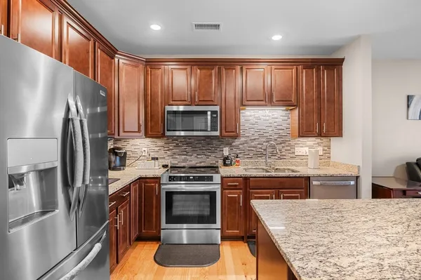 a kitchen with stainless steel appliances granite countertop a refrigerator stove and sink