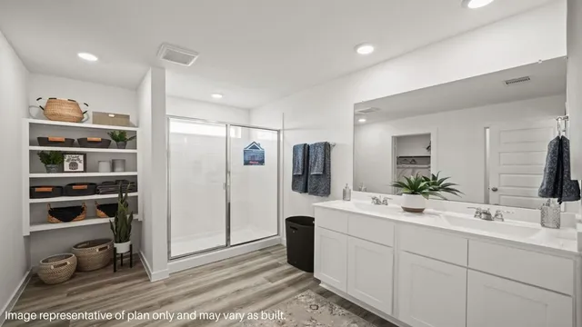 a spacious bathroom with a double vanity sink a mirror and shower