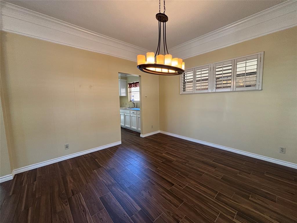 4702 Ranch View Road Fort Worth, TX 76109 - Photo 6 of 40 Dark wood-finish flooring, crown molding, and a chandelier with a bronze-finish frame