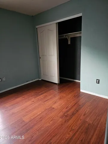 an empty room with wooden floor and closet