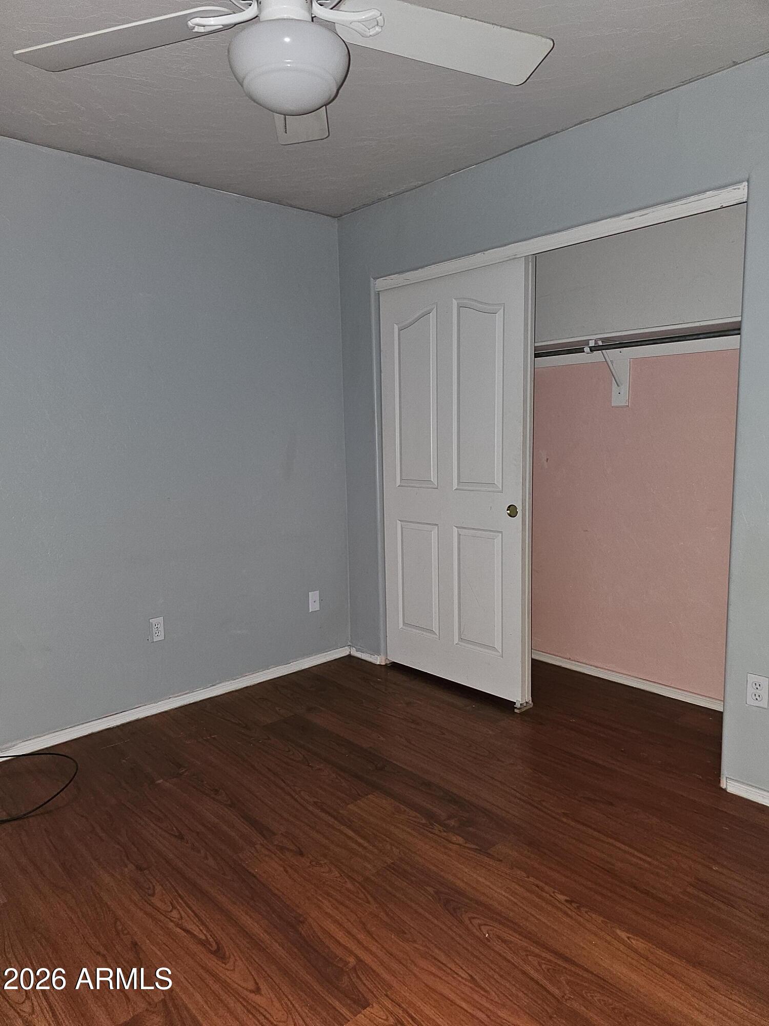 1489 West Page Avenue Gilbert, AZ 85233 - Photo 8 of 9 a view of an empty room with wooden floor and closet