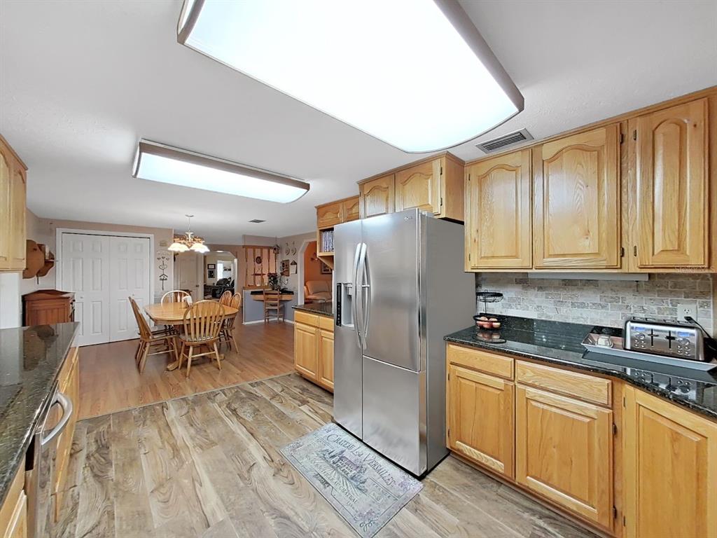 4105 Robinson Road Valrico, FL 33594 - Photo 22 of 58 a kitchen with stainless steel appliances granite countertop a refrigerator a sink dishwasher a stove and white countertops with wooden floor