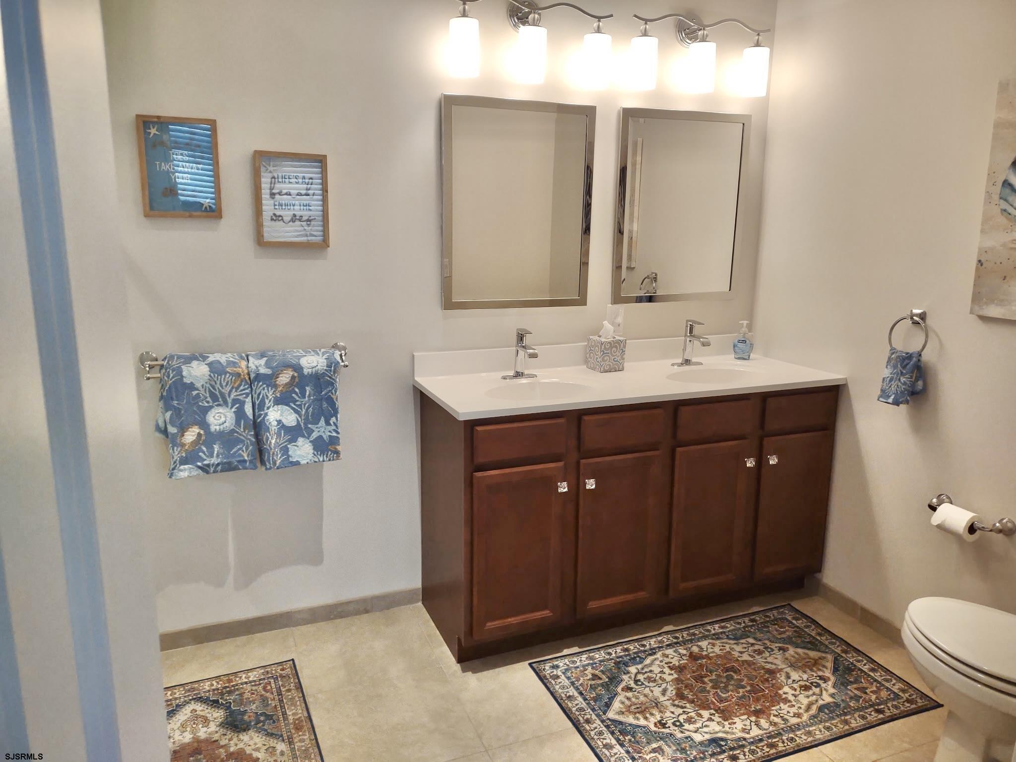810 Asbury Avenue, Unit 303 Ocean City, NJ 08226 - Photo 11 of 20 a spacious bathroom with a toilet a sink and mirror