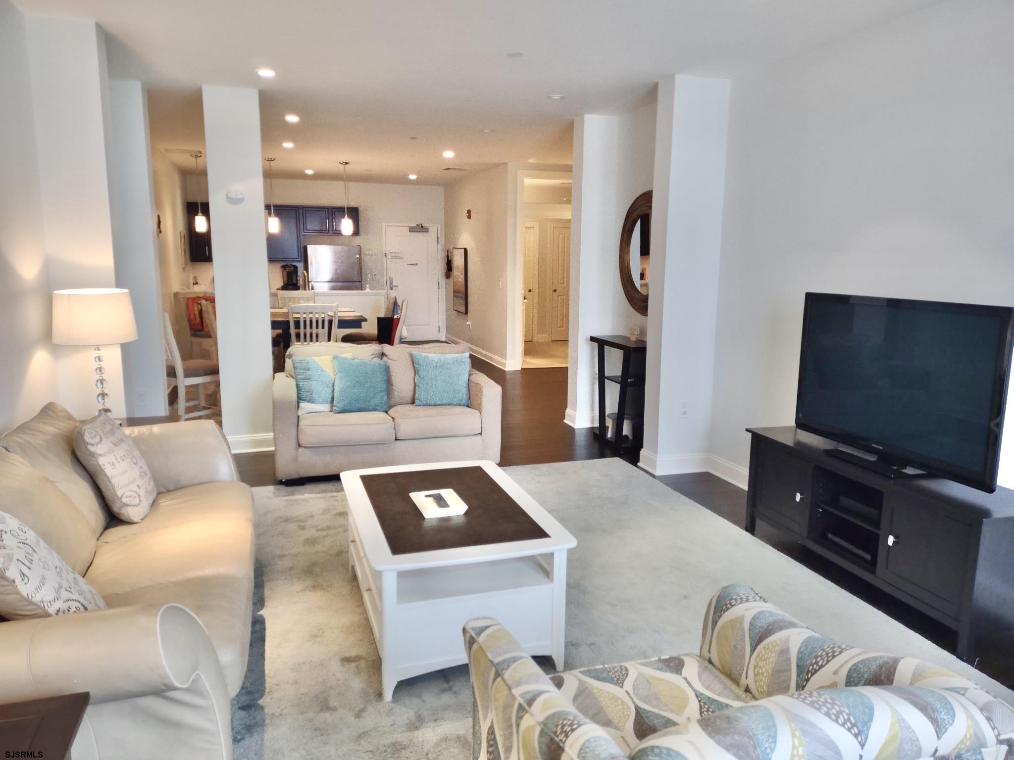 810 Asbury Avenue, Unit 303 Ocean City, NJ 08226 - Photo 7 of 20 a living room with furniture a flat screen tv and kitchen view